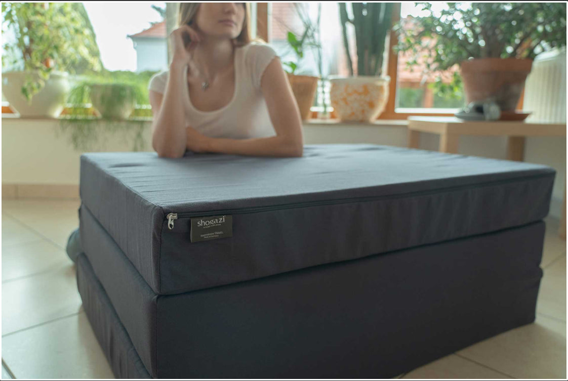 Zusammengeklappte 15 cm hohe Klappmatratze mit abnehmbarem Bezug und Reißverschluss, hergestellt in Deutschland, platzsparend aufgestellt