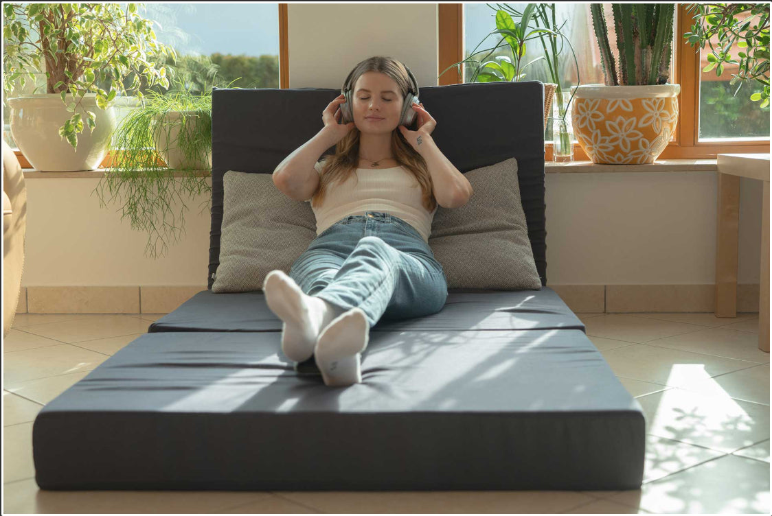 Person entspannt auf 15 cm hoher Klappmatratze aus orthopädischem Kaltschaum und Visco, mit hautfreundlichem Baumwollbezug, atmungsaktiv und klimaregulierend