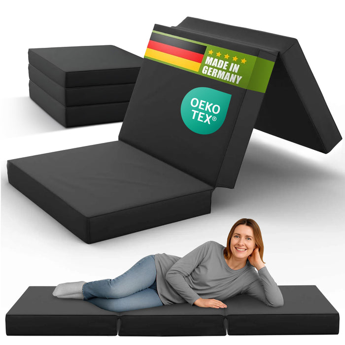Frau liegt entspannt auf einer schwarzen Klappmatratze 90x200 cm, hergestellt in Deutschland, OEKO-TEX® zertifiziert.