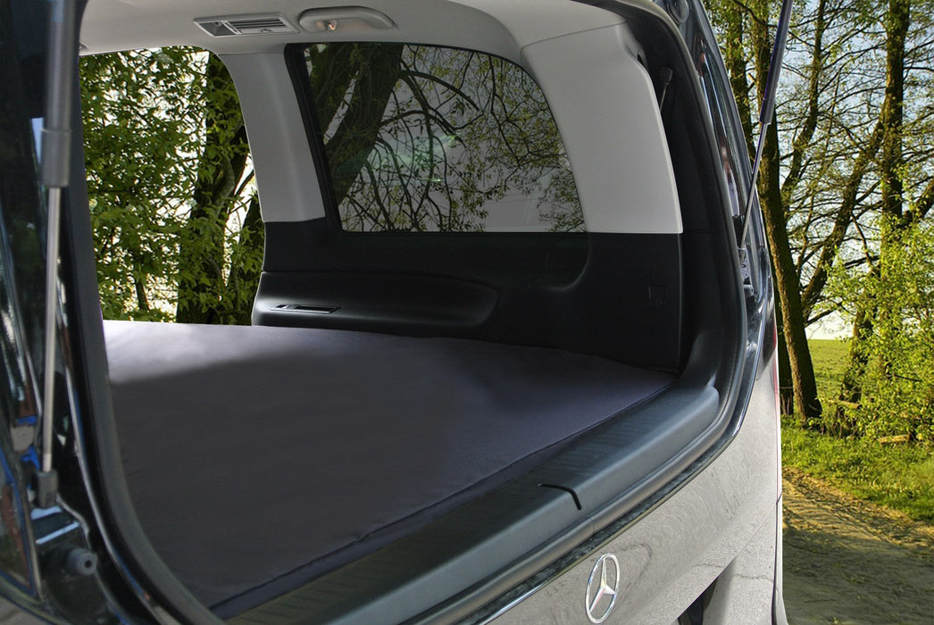 Blick durch die geöffnete Heckklappe des Mercedes Vito auf die voll ausgelegte shogazi® Matratze – maßgefertigt für den Fahrzeuginnenraum, nahtlos eingefügt für erholsames Schlafen unterwegs im Grünen.